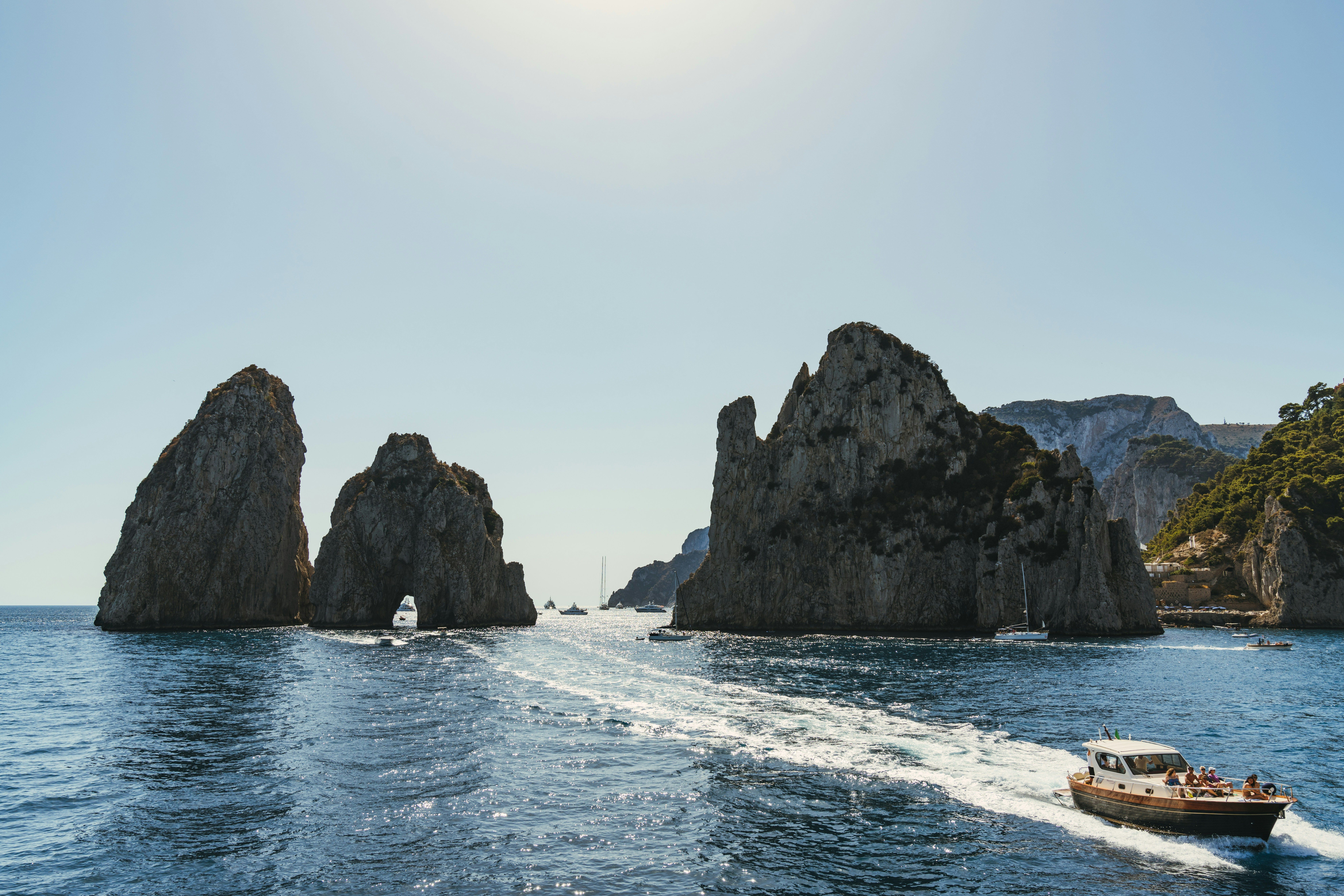 boat sailing across the sea with cliffs behind