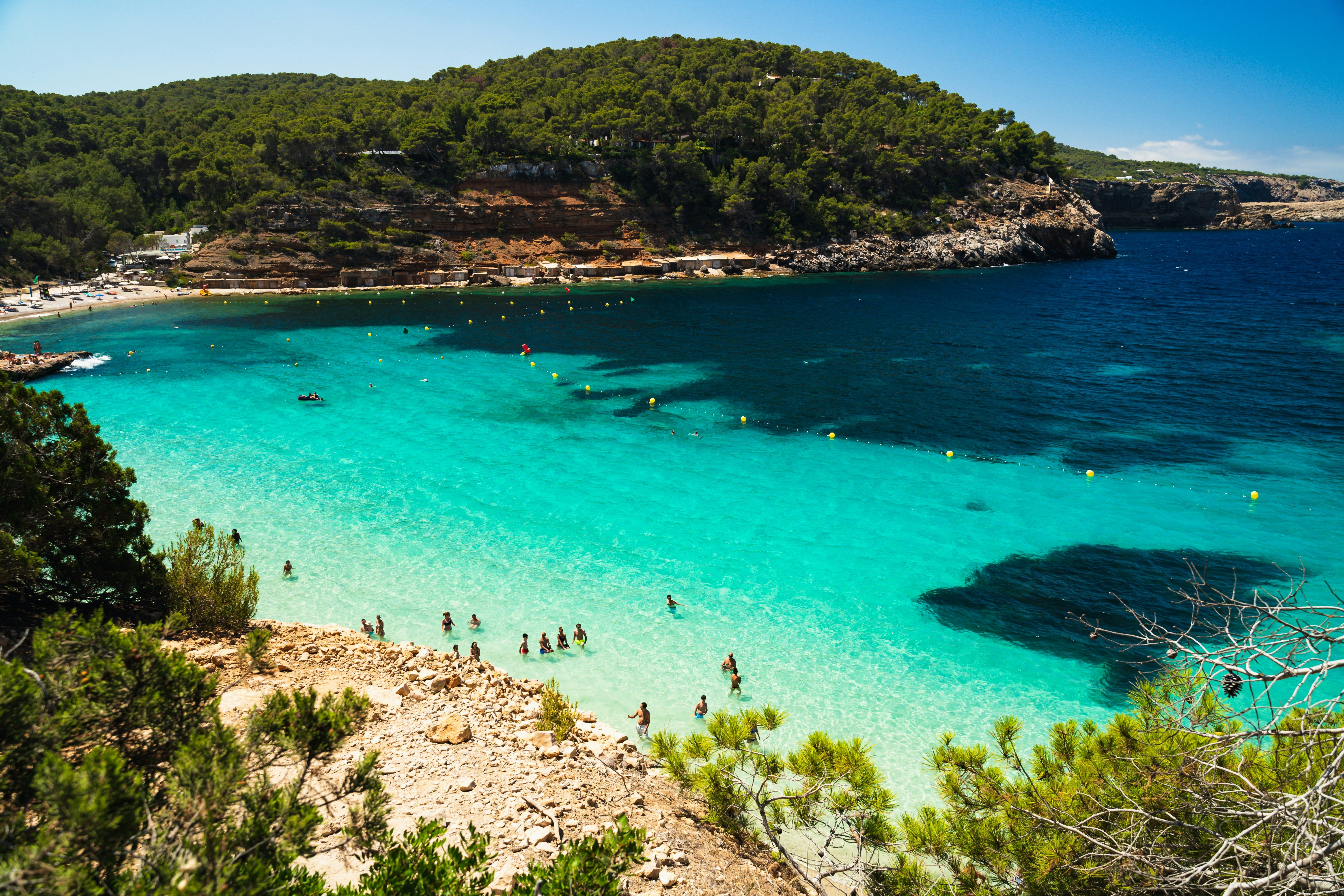 people swimming in a clear bay in Ibiza