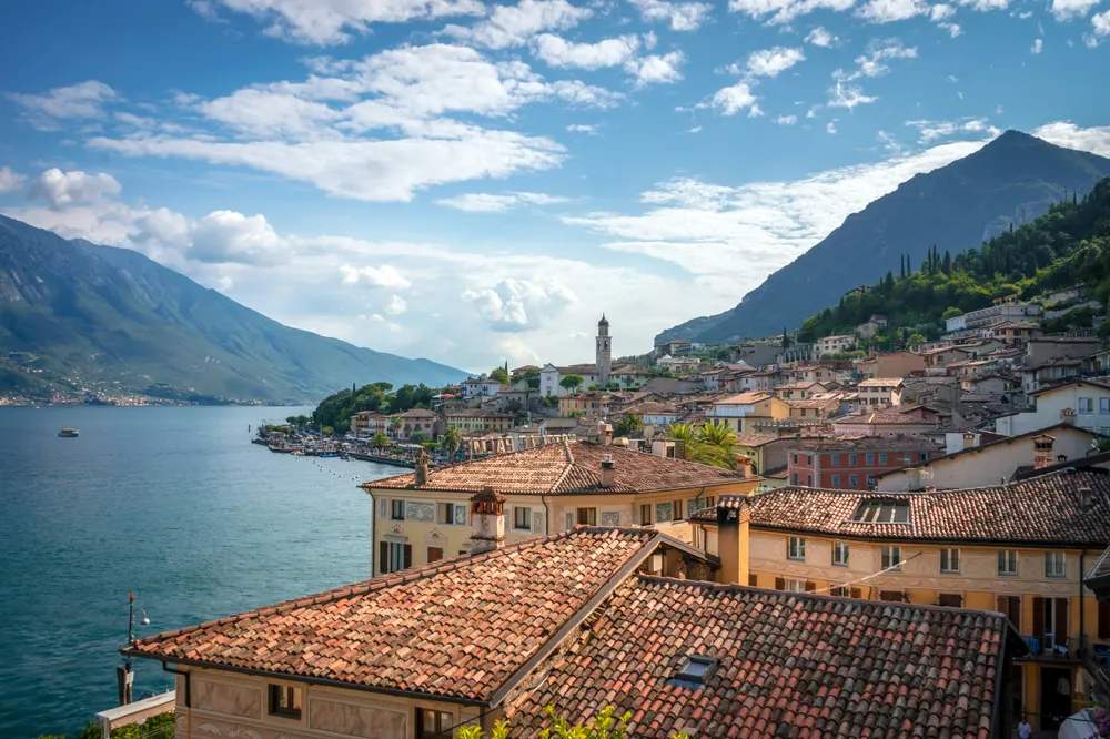 Pueblo a orillas del Lago de Como con tejados de teja y montañas alrededor