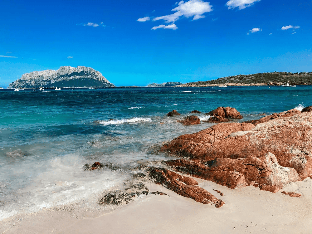 plage avec rochers et mer donnant sur une ile