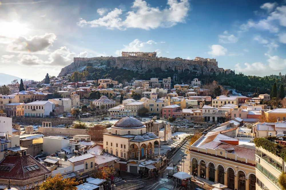 the sun setting on Athens with the Acropolis in the distance