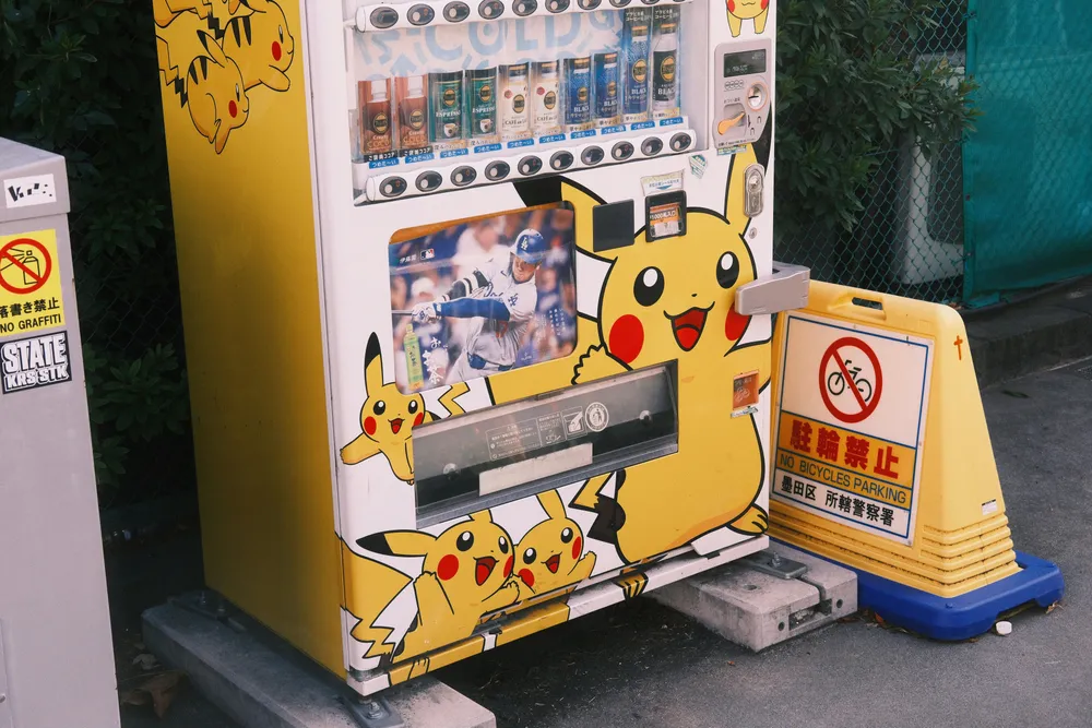 Ein Automat, der mit Pikachus bemalt ist. Am Automaten kann man Pokemon-Karten kaufen.