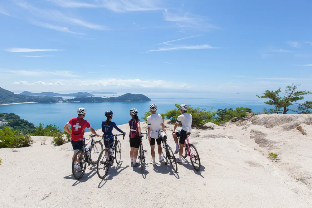 A family on bicycles stopping to admire the sea views