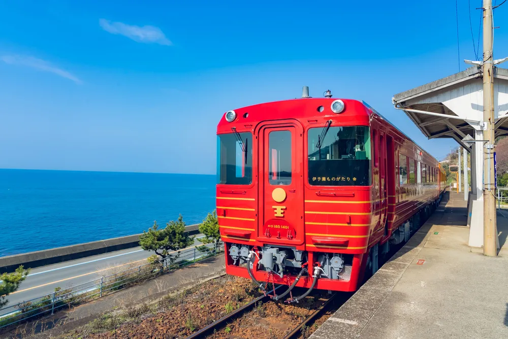 Treno rosso in una stazione vicino al mare