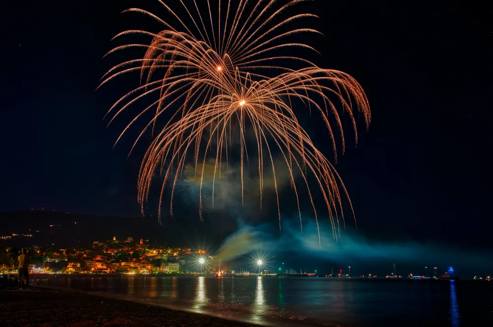 Searat di festa sul lungomare con fuochi d'artificio.