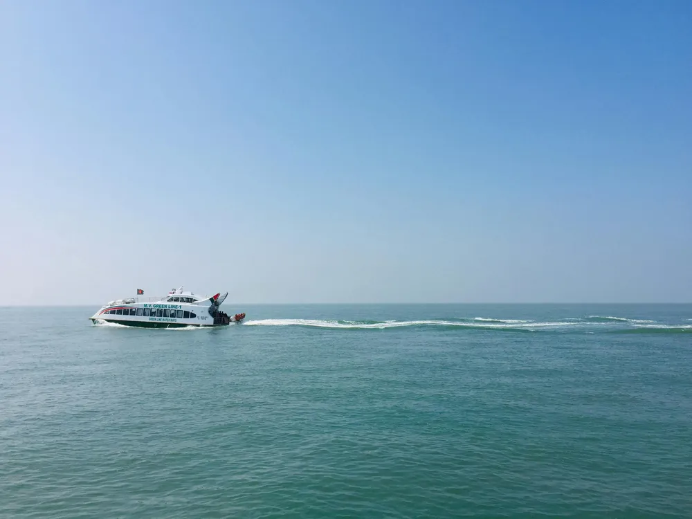 Ein weißes Speedboot düst bei strahendem Sonnenschein über das blaue Meer.