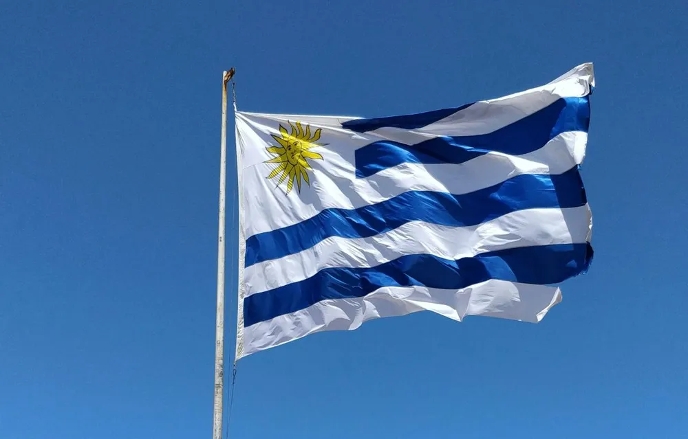 Bandera de Uruguay ondeando junto a la costa atlántica, símbolo del país y de las escapadas desde Argentina cruzando el Río de la Plata
