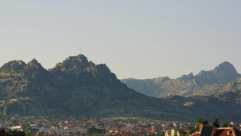 ville avec montagne et croix sur sommet
