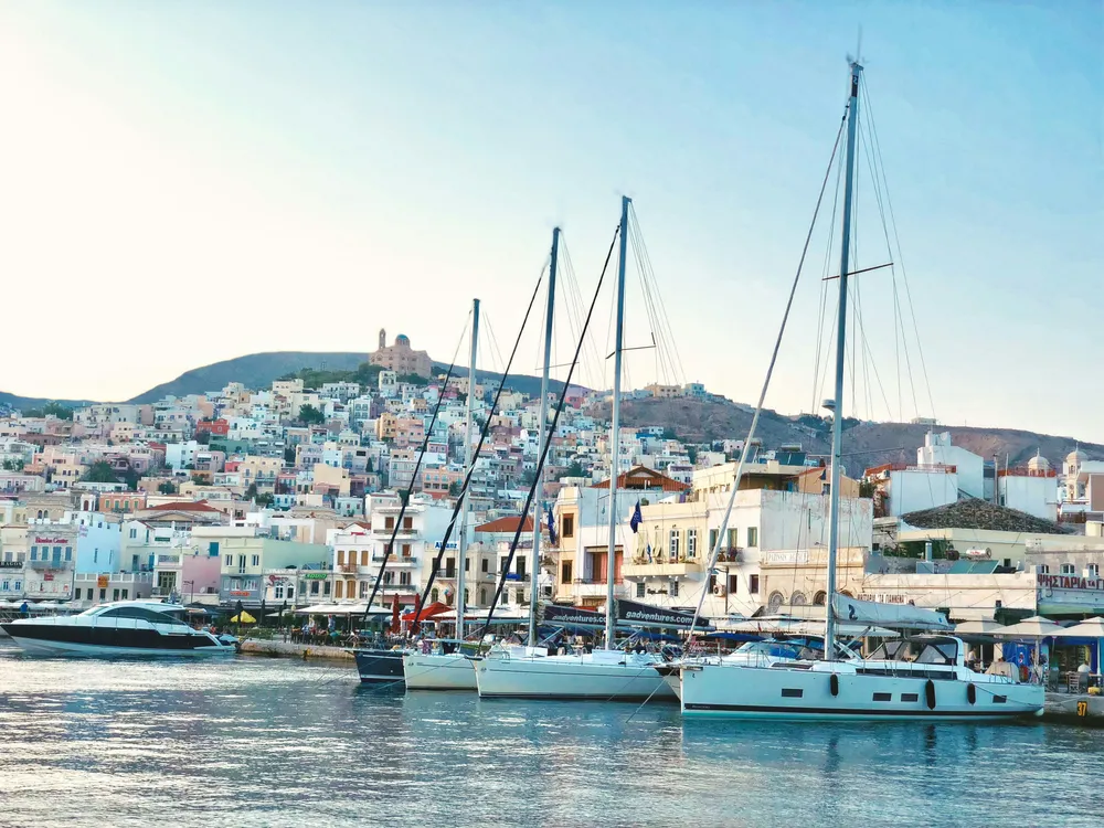 boats docked along the port with Syros town in the background