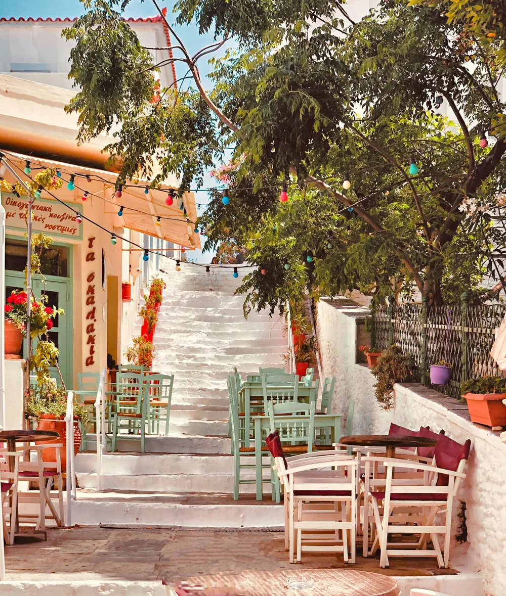 wooden tables by white steps in Andros town