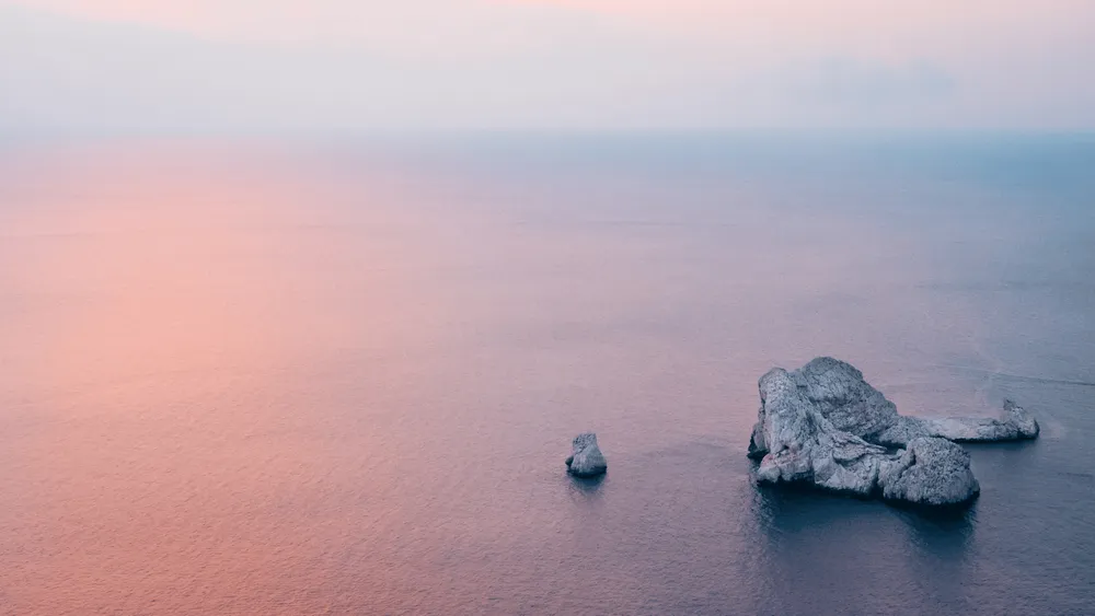 mer avec coucher de soleil et rocher blanc