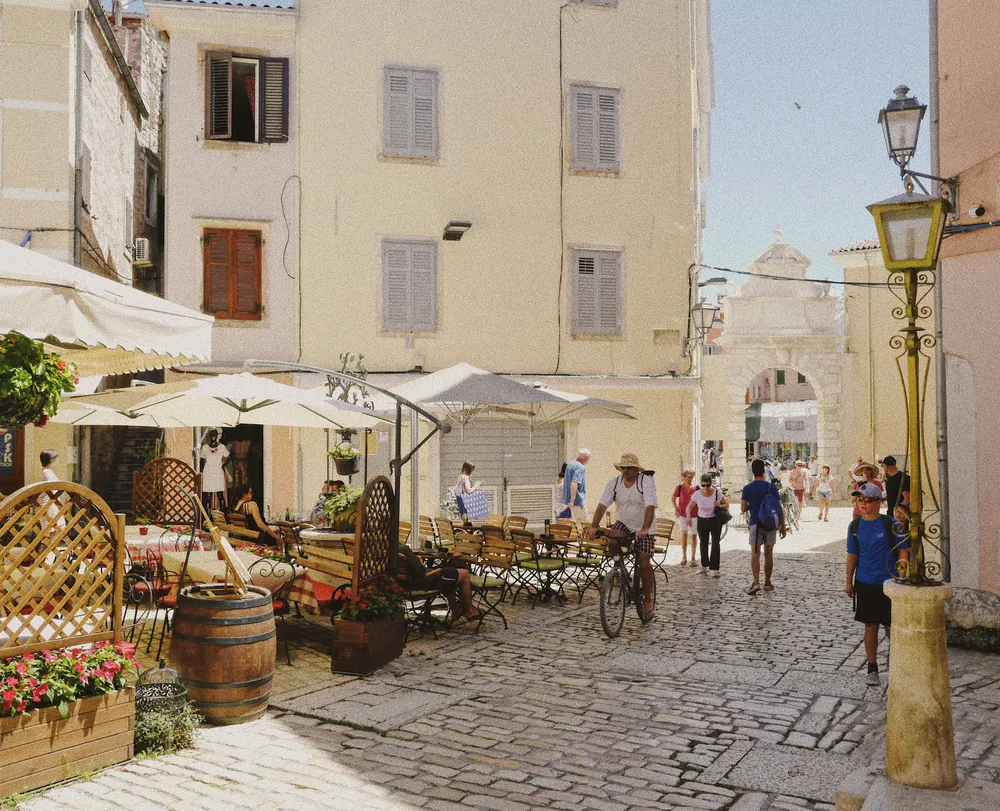 ruelle pavee de rovinj avec terrasse et gens
