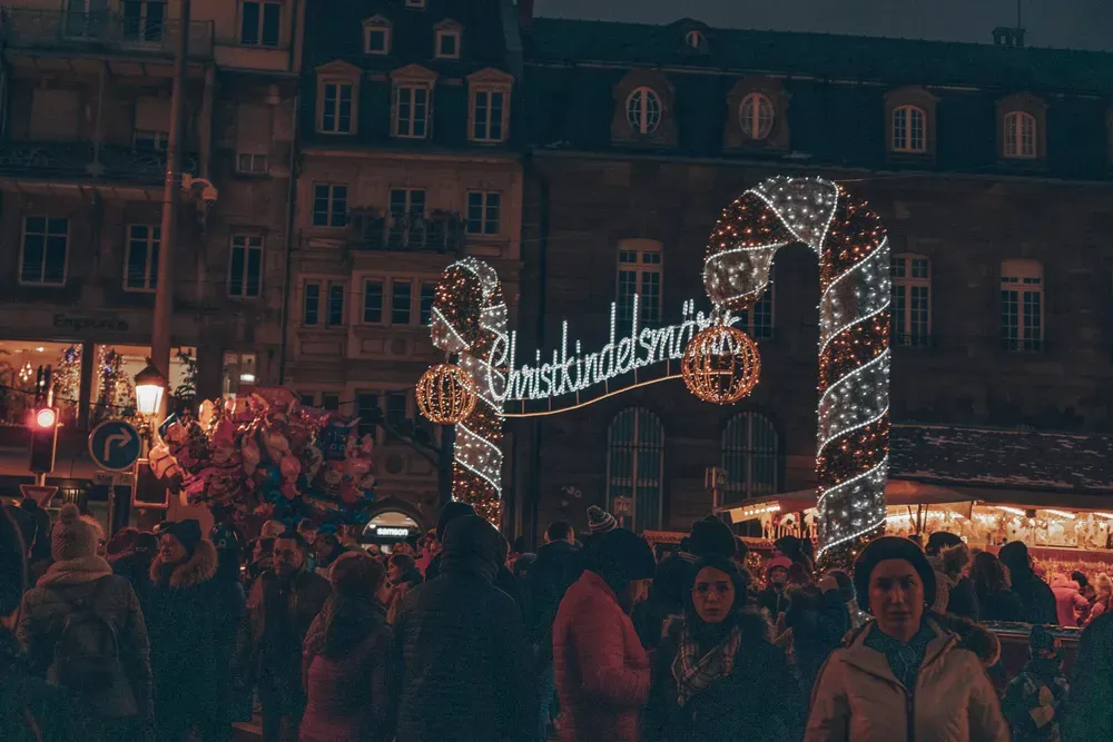 Der Eingang zum Christkindlmarkt in Straßburg funkelt und glitzert in der Dunkelheit.