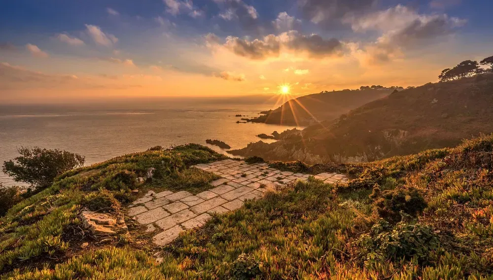 The sun setting along the coastline in Guernsey