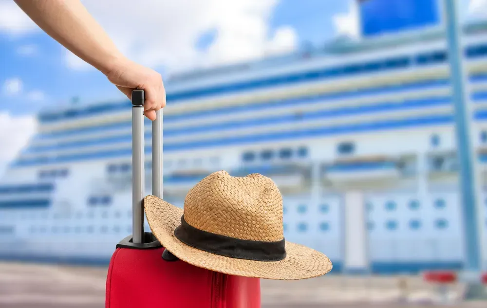 hat sat on a suitcase by a ferry