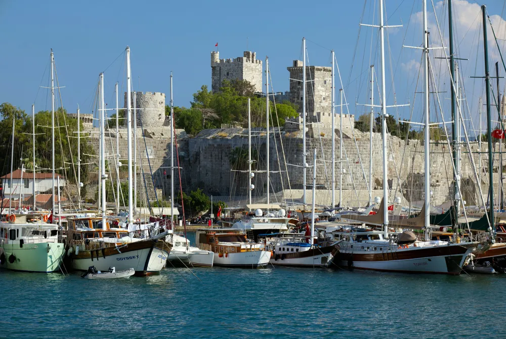 Zeilboten liggen in de haven van Bodrum, met het oude kasteel op de achtergrond.