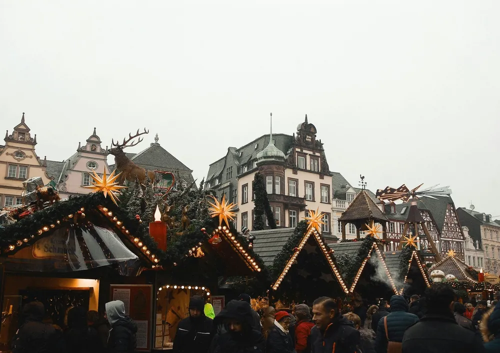 Een rij kerstmarktkraampjes in Duitsland met gebouwen op de achtergrond