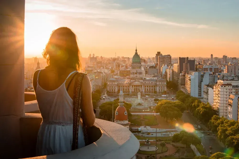 a woman looking out over Buenos Aires at sunset