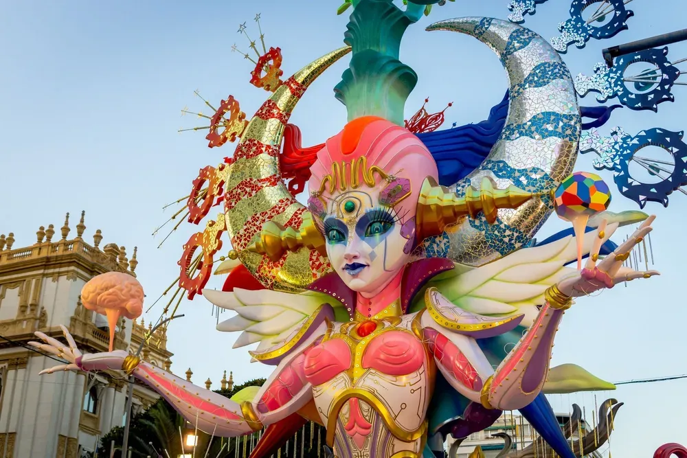 Eine meterhohe Figur, die zum Las Fallas-Festival in Valencia erbaut wurde. Die Figur ist hauptsächlich in Rot- und Blautönen gehalten und wird wie bei einem Karnevalsumzug in der Stadt präsentiert.