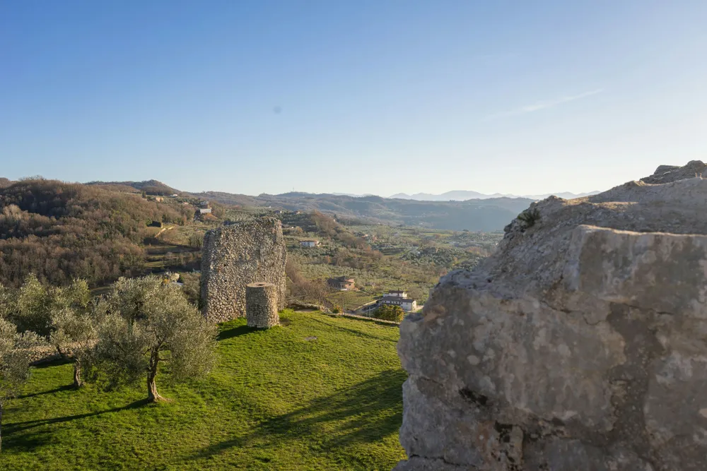 ruins on grass with green hills in the background