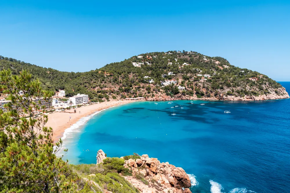 sandy bay in between green hills in Ibiza
