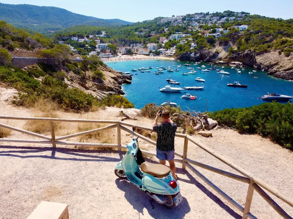 man taking a photo of a bay in Ibiza