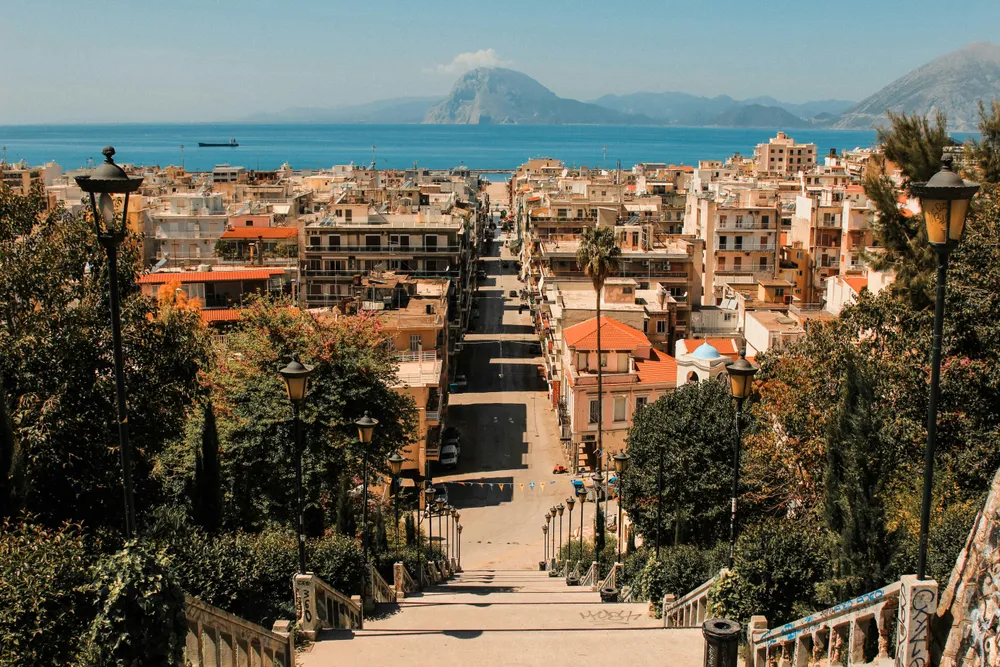 steps leading to a street with the sea in the distance