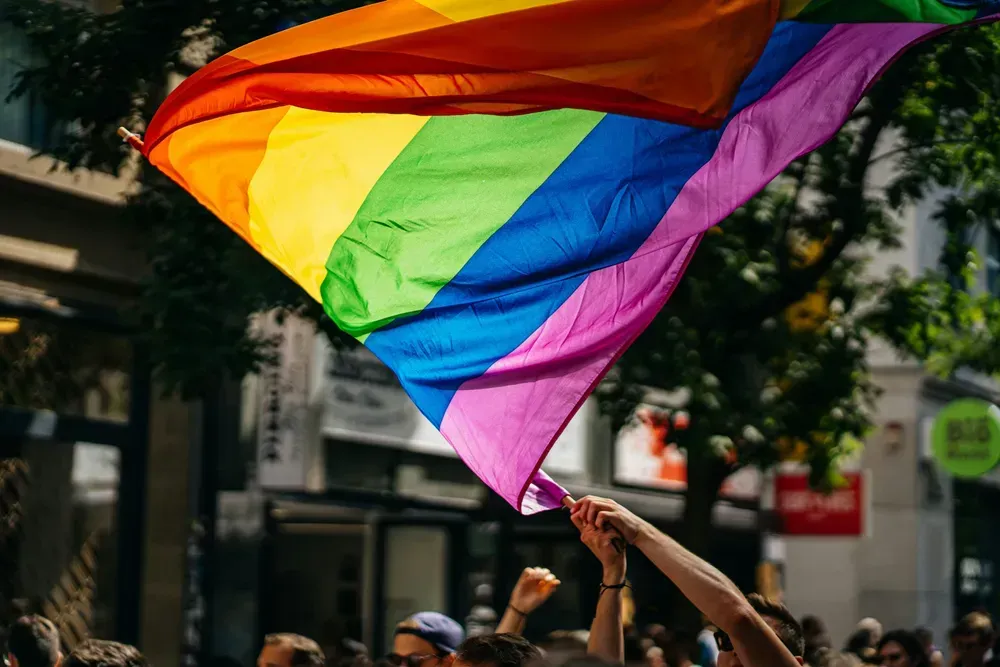 person waving flag during a Pride parade