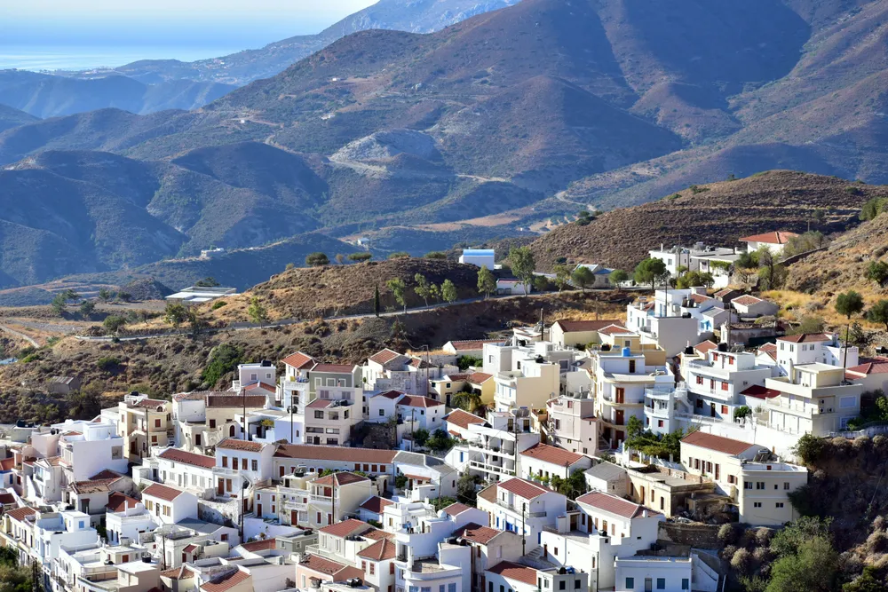 batiments de karpathos sur flanc de montagne avec vegetation