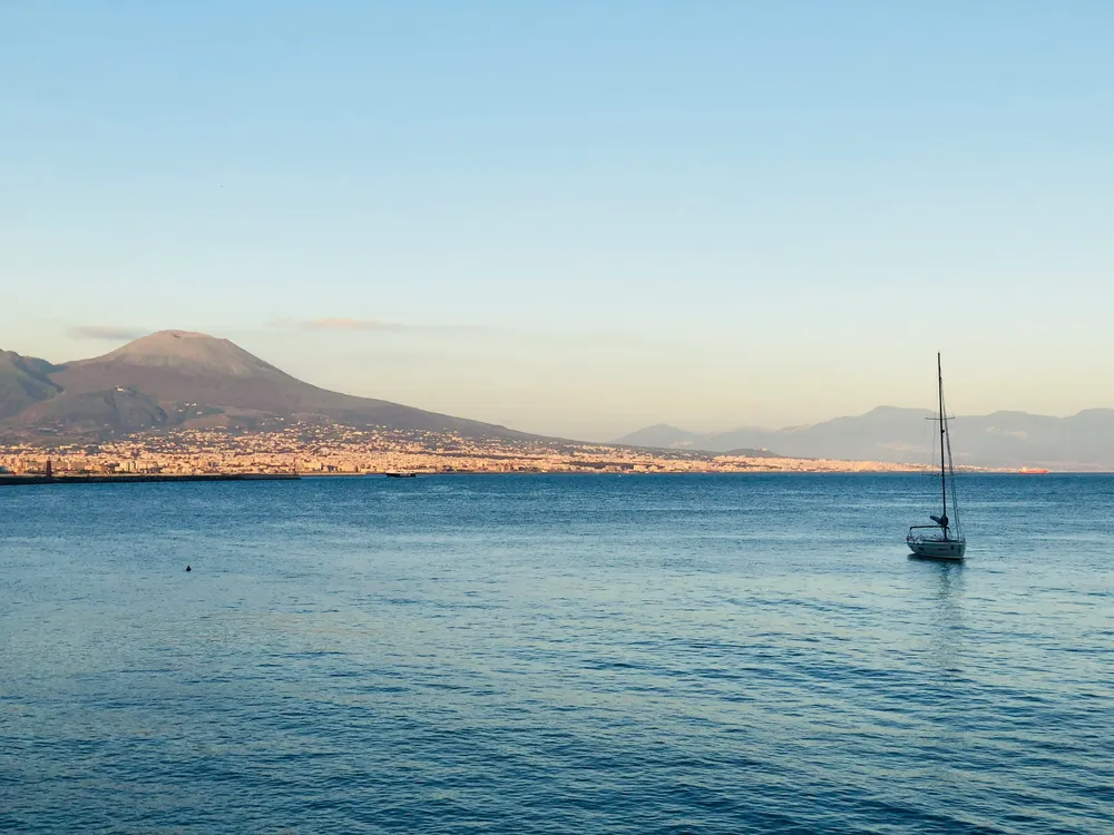 vue sur la mer avec voilier et vesuve au fond