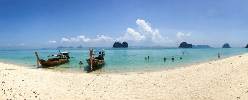 long-tail boats on a sandy beach in Koh Lanta