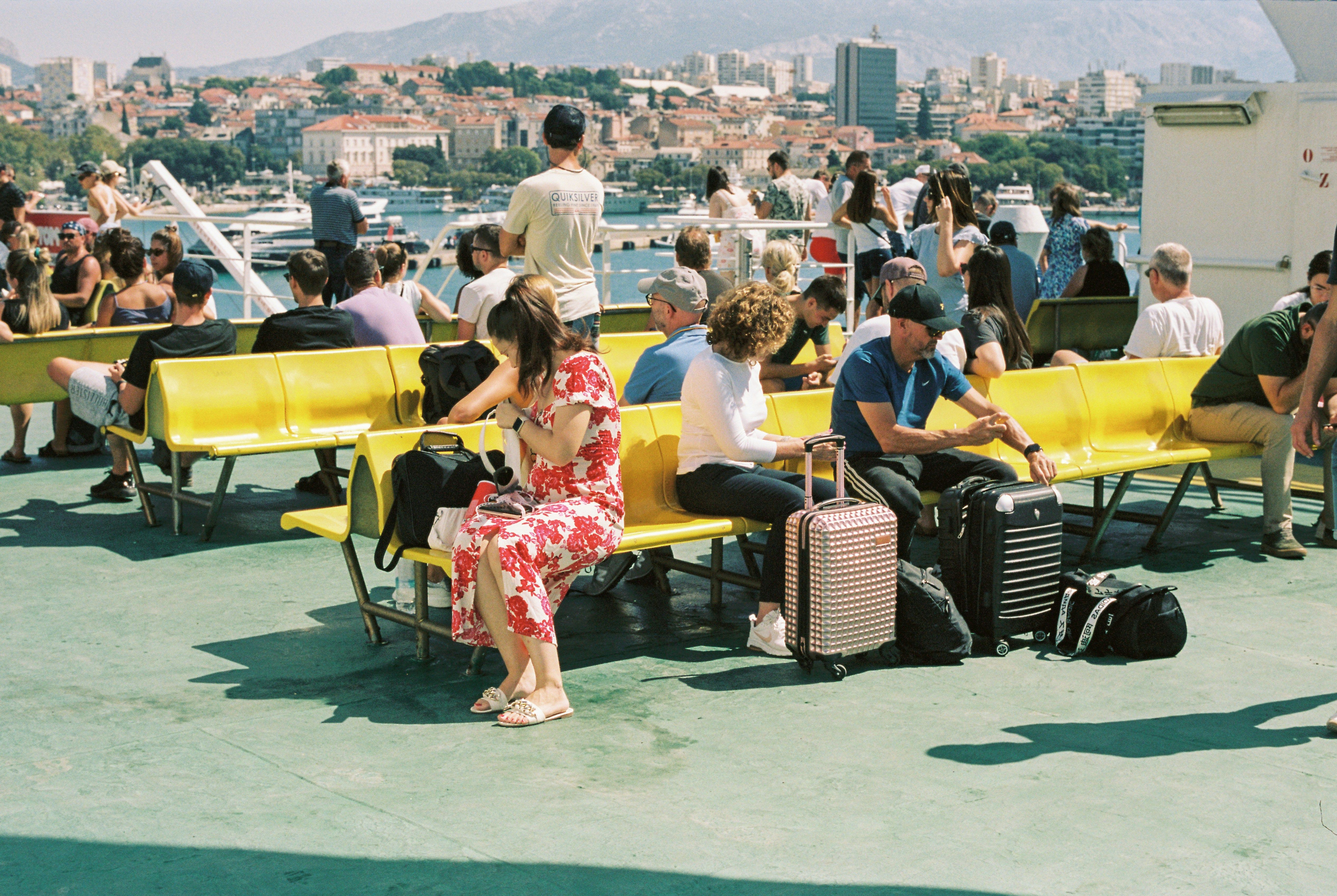 people sat on an outside deck on a ferry