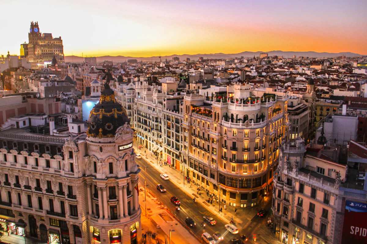 Atardecer sobre la Gran Vía de Madrid, con el edificio Metrópolis iluminado.