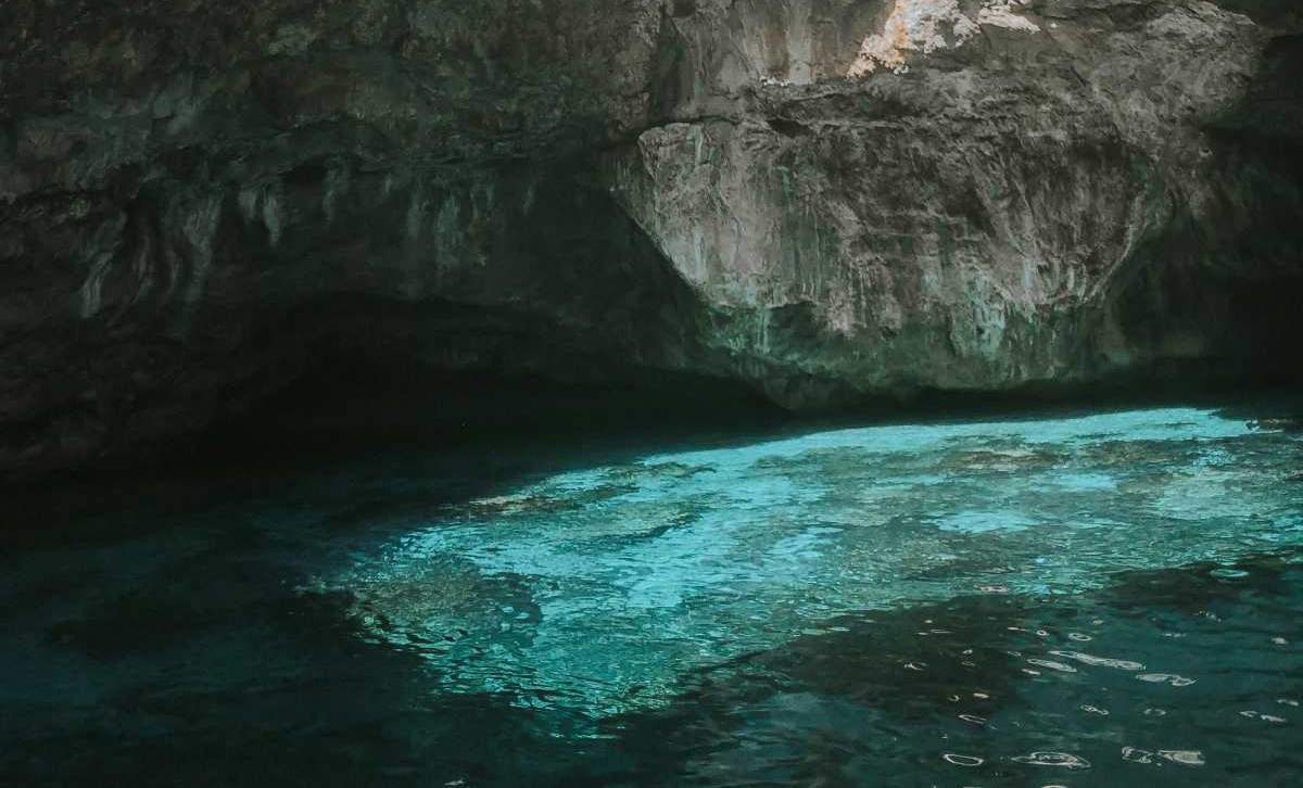 Interior de una cueva marina en Marettimo con agua azul esmeralda iluminada por la luz natural