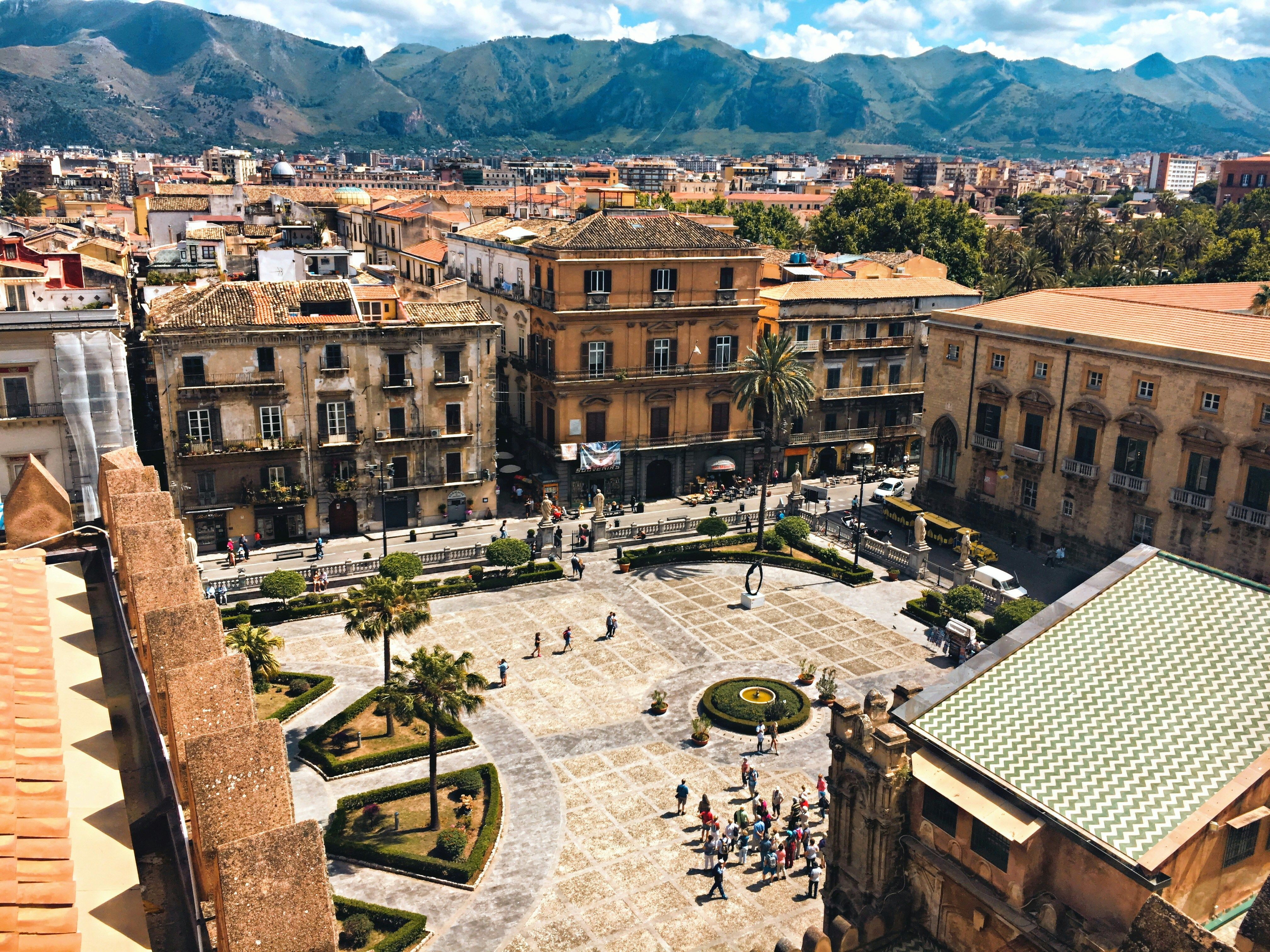 square lined with buildings with mountains in the background