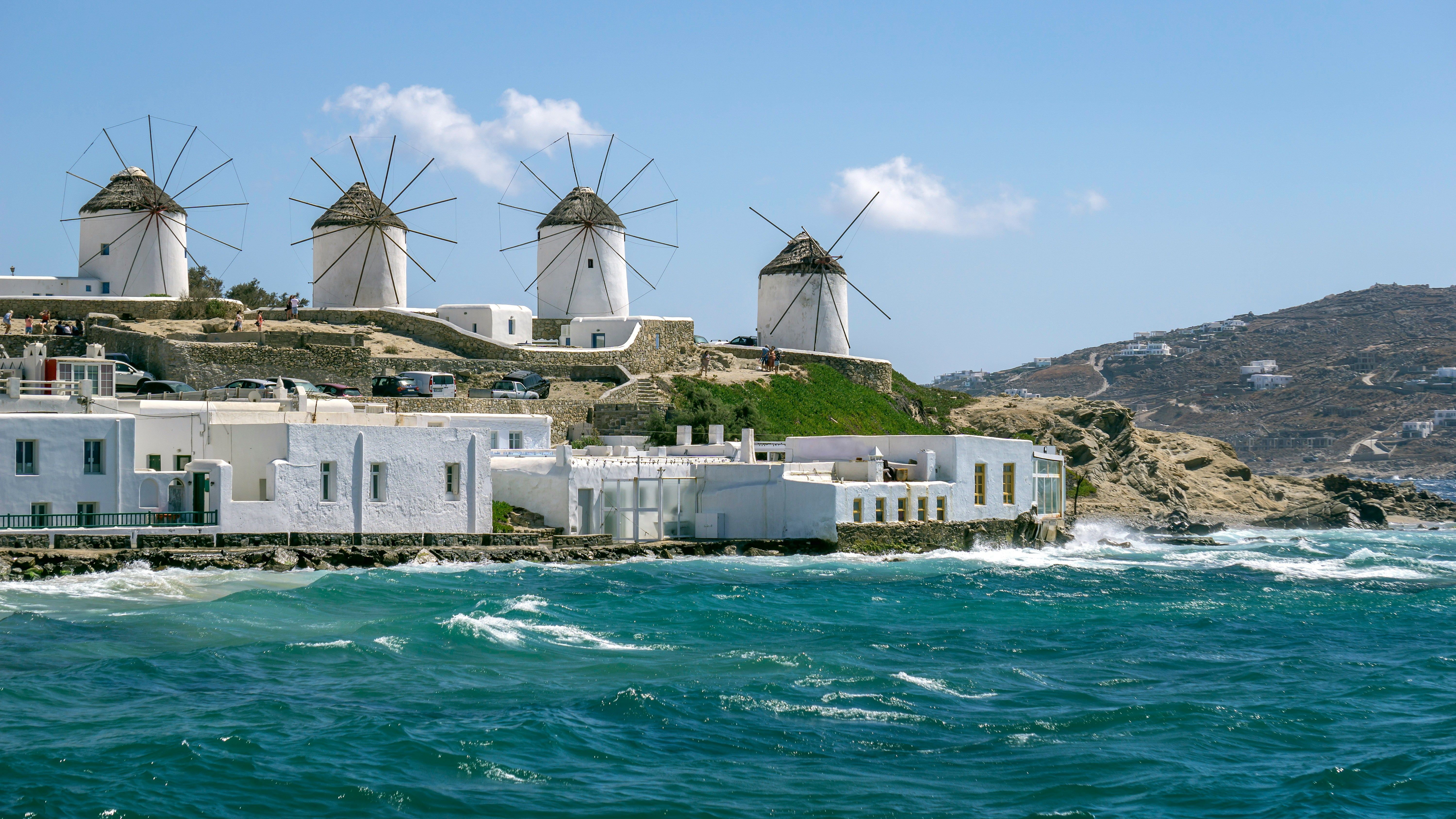 windmills on hill overlooking the sea