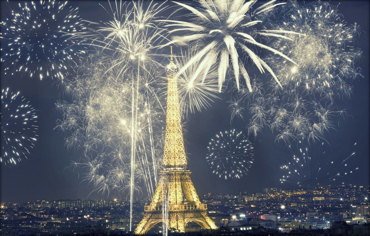 La Torre Eiffel circondata da fuochi d'artificio che illuminano la notte di Parigi.