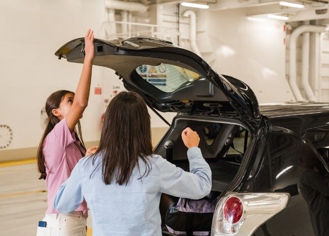 Dos pasajeras preparando el equipaje en el interior de un ferry mientras descargan su coche