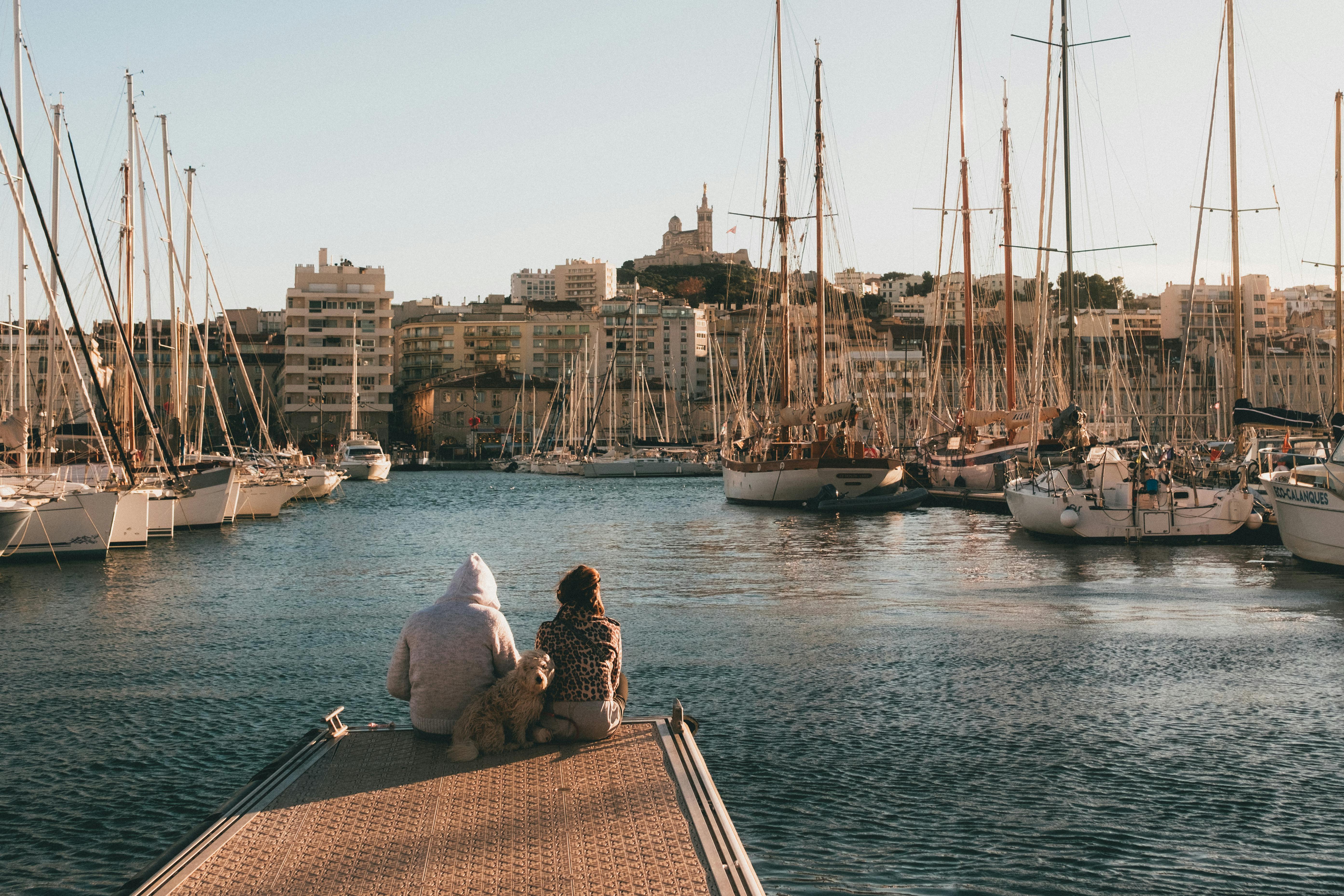 Couple sitting at the port with their furry friend.