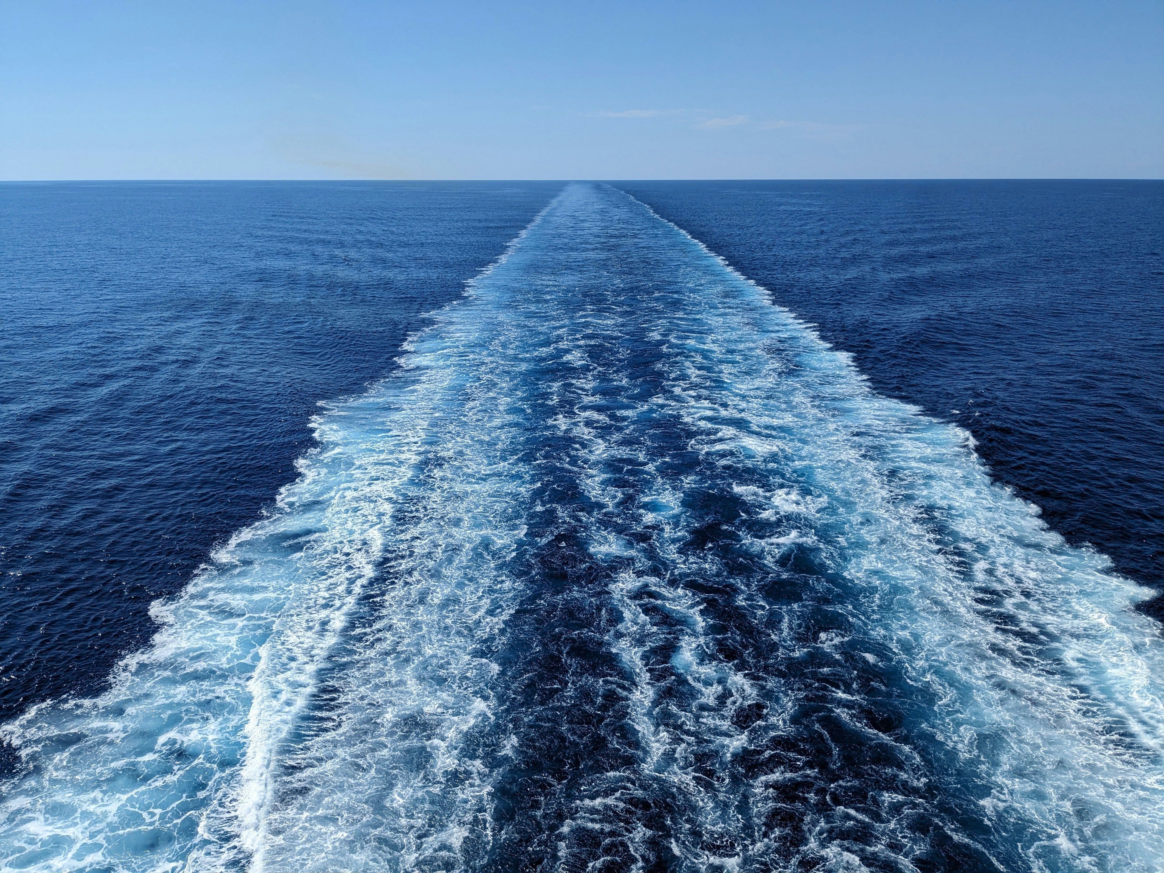 Der Blick vom Heck einer Fähre, die einen Schweif im Wasser hinterlässt.