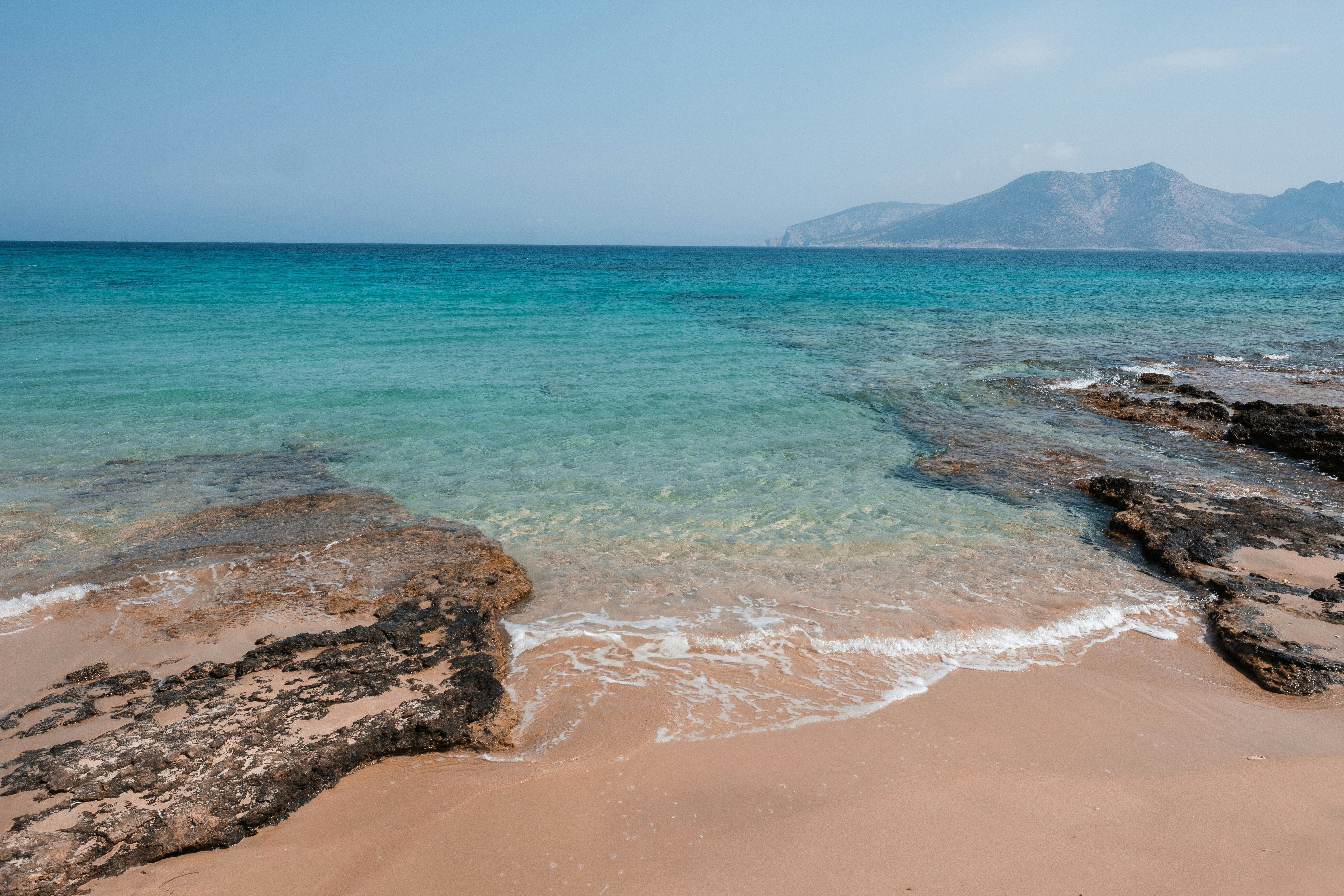 plages rochers mer et montagne au fond