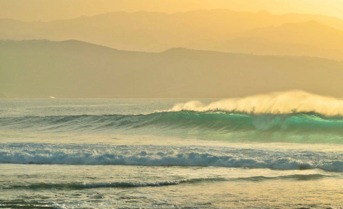 Ola rompiendo al atardecer en la Playa de El Confital, Tenerife.