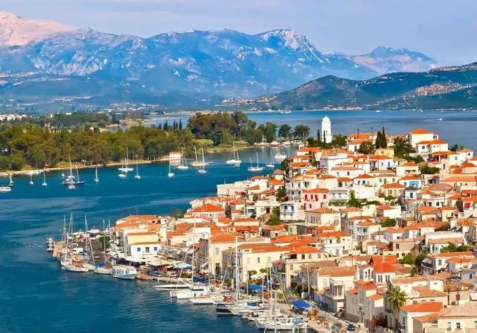 Vista panorámica del puerto de Poros con casas de tejados rojos y montañas al fondo, Islas Sarónicas, Grecia