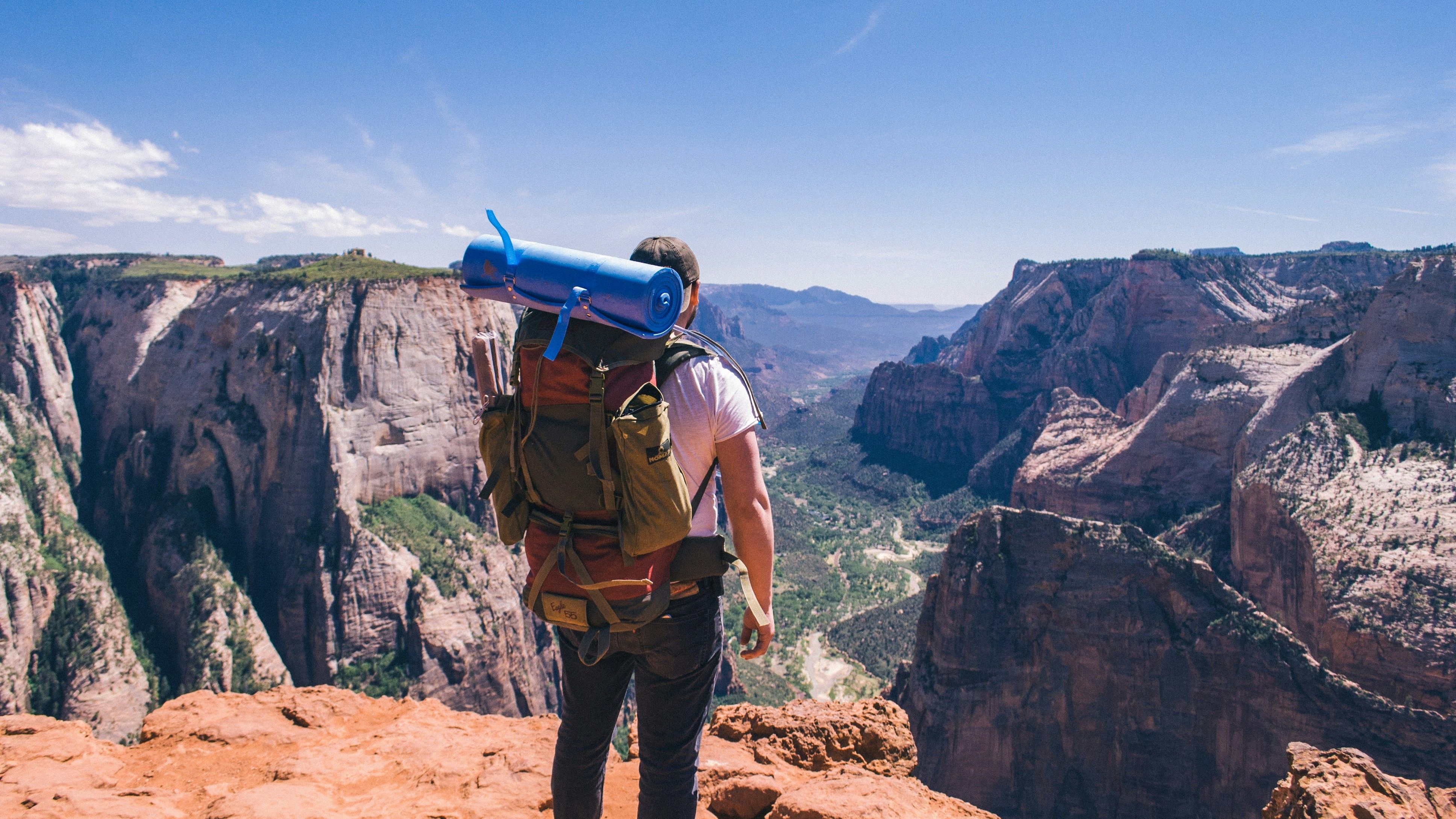 man with a backpack on the top of a mountain