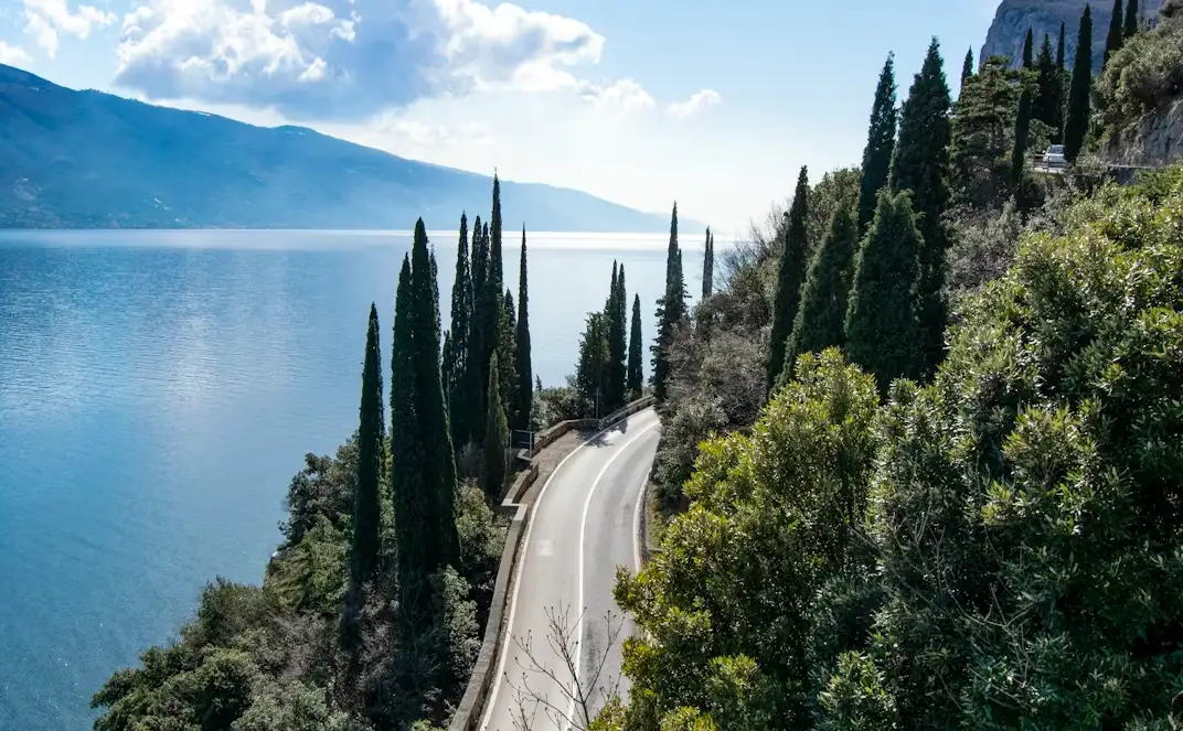 Carretera panorámica junto al lago de Garda en invierno rodeada de cipreses