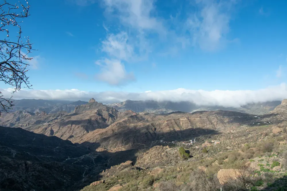 rugged mountains with low clouds and blue skies