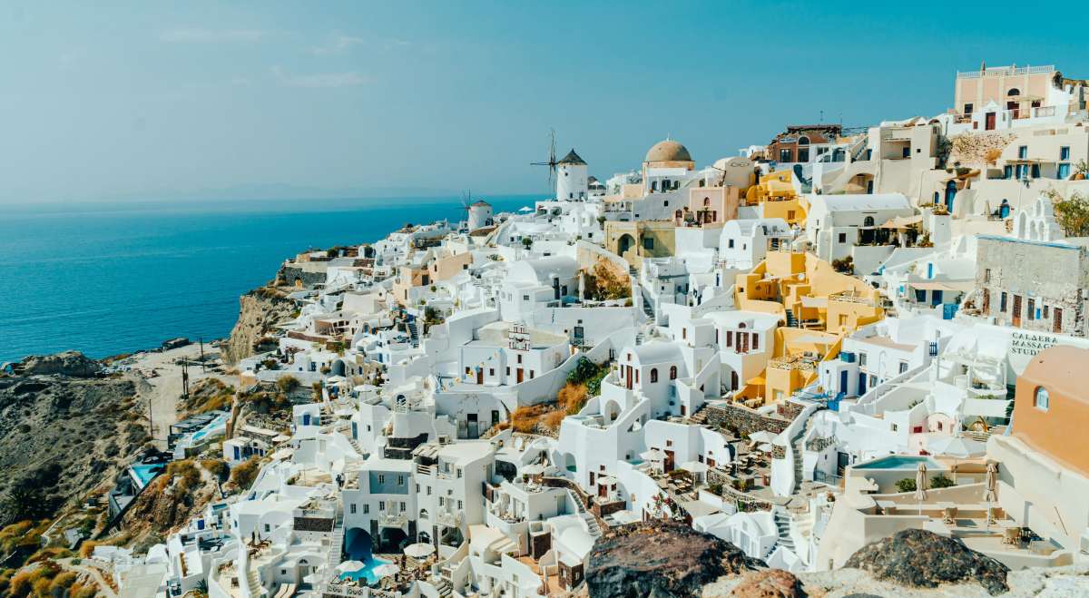 vista panorámica de Santorini con sus casas blancas y cúpulas azules frente al mar Egeo