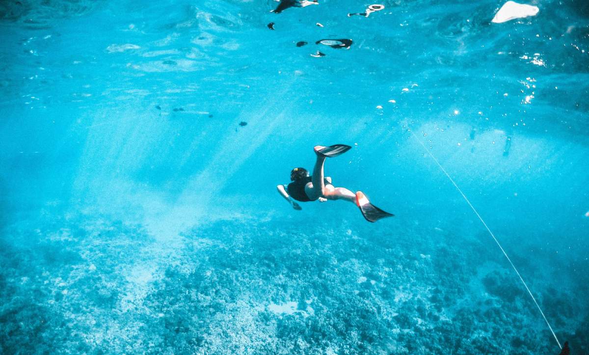 Turista practicando snorkel en aguas cristalinas de Mallorca, actividad sostenible en el mar