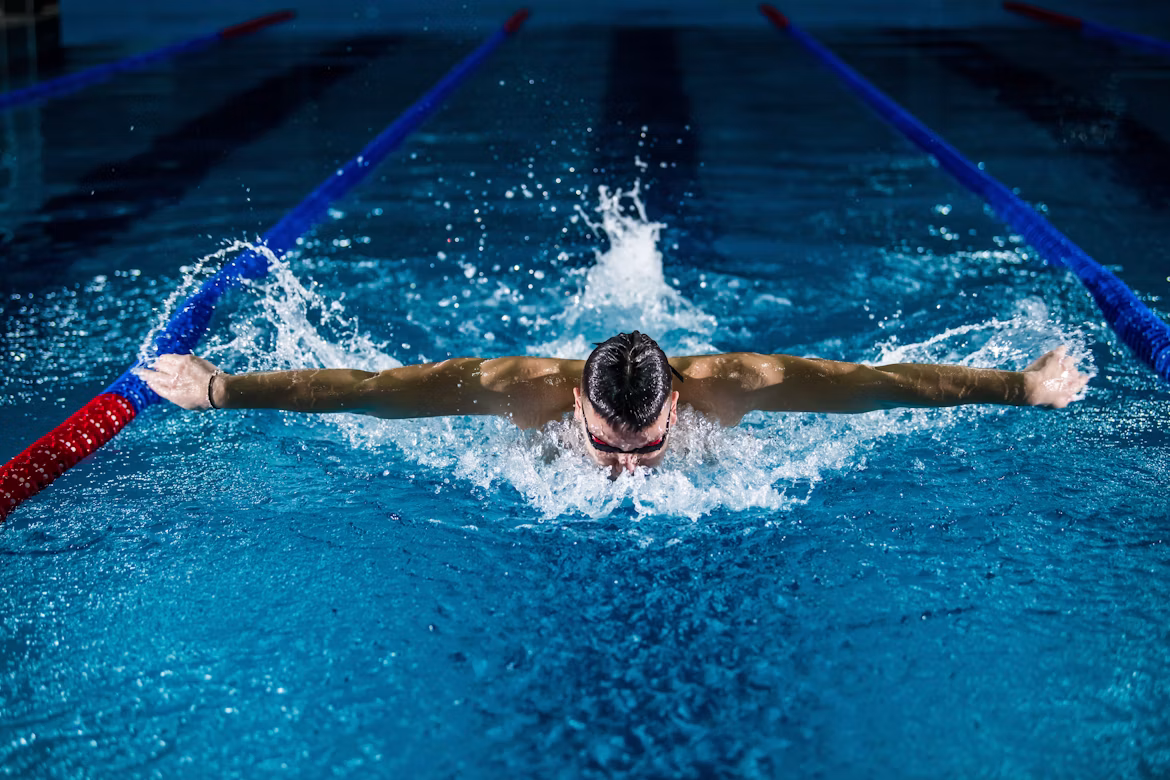A swimmer doing the butterfly stroke in a swimming pool