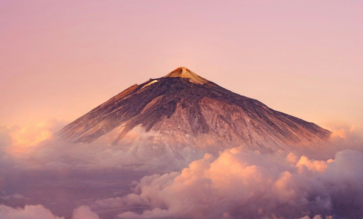 Montaña del Teide al atardecer entre nubes en Tenerife, Islas Canarias.